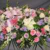This feminine casket spray is full of soft pink and lavender Roses