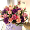 This stunning arrangement showcases a lovely variety of fresh flowers in delicate