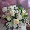 Bouquet of all white flowers to include lily, roses, poms, white ribbon