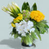 Bouquet of yellow roses, white orchids, and calla lilies in a glass vase