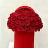 Red roses arranged in a round red hat box