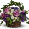 Basket arrangement of pink, white, and purple roses with ivy