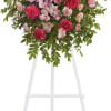 Pink and magenta floral standing spray on a white easel