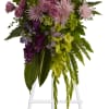 Tall floral standing spray with purple, pink, and green flowers on a white easel