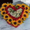 Heart-shaped bouquet of red roses and sunflowers with white flowers