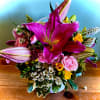 A cheerful woven basket overflowing with fresh spring blooms. This arrangement features