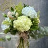 This enchanting vase features a delightful arrangement of soft-colored hydrangeas, showcasing a