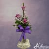 Pink roses in a glass vase with a purple ribbon