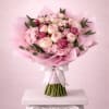 Pink bouquet of peonies and hydrangeas wrapped in pastel paper