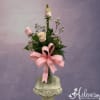 Pink and white roses in a glass vase with a large pink ribbon