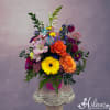 Colorful mixed flower arrangement in a pink container