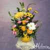 Mixed yellow, pink, and white flowers in a smiley-face pot
