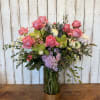 A dreamy garden-style arrangement designed in a clear glass vase with a