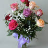 A beautiful assortment of mixed color roses, with greenery and babies breath