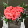 Nine beautiful roses arranged in a modern glass cube vase, creating a