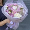 Pink and white bouquet wrapped in lavender paper