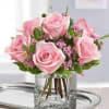Pink roses arranged in a clear glass vase