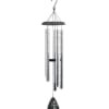 Silver metal wind chime with black top and cross motif sail on white background