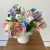 Pastel bouquet of mixed flowers in a white vase