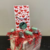 Heart-patterned gift box with wrapped chocolates on a wooden crate