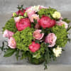 This bouquet contains seasonal mixed florals such as green hydrangeas, coral peonies