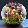 This arrangement contains mixed colors ranunculus set into 12in bubble ball vase.