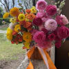 A romantic basket arrangement in a rich dark pink and orange color