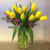 Clear cylinder vase of tulips with a touch of tiny blossoms. 