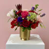 A captivating arrangement of red, hot pink, and soft blush blooms accented
