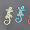 Four colorful gecko-shaped cutouts on a dark background