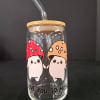 Clear glass tumbler with a straw and cartoon mushroom design