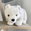 White plush polar bear with a price tag on a wooden shelf