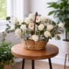 A beautiful white basket arranged with fresh flowers and delicate details, created