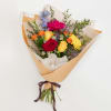 Mixed bouquet of roses, gerbera daisies, and other blooms wrapped in paper