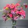 Pink mixed bouquet in a clear glass vase with gerbera daisies and roses