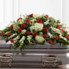 Red roses and white flowers arranged on a casket