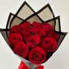 Bouquet of red roses wrapped in black and gray paper with a red ribbon