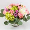 Pink and purple roses with hydrangeas in a glass vase