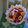 The breathtaking arrangement of 50 roses mixed with vibrant sunflowers, wrapped in