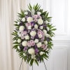 A serene and elegant lavender and white standing spray, thoughtfully arranged to