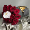 Bouquet of red roses with a white orchid on dark wrapping