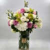 Bouquet of white, pink, and green flowers in a clear glass vase