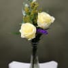 Two beautiful roses arranged with fresh greenery in a petite vase. This