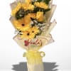 Yellow gerbera bouquet wrapped in cream paper with a yellow ribbon