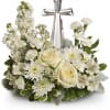 White floral arrangement with roses and daisies around a silver cross