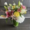 A medium height cylinder vase filled with hydrangeas, lilies, roses, dahlias, lisianthus