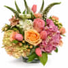 This low centerpiece is complete with peach roses, tulips, snap dragon, stock