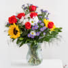 A joyful burst of color, this lively arrangement features bold red roses