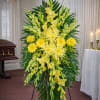 The Sunny Bright Funeral Standing Spray from FloralFabulous is a vibrant and