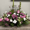 Pink and white floral arrangement with a clear cross centerpiece